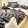 Dark grey patterned reversible throw with a cream sherpa underside