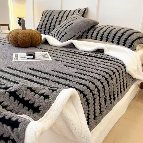 Dark grey patterned reversible throw with a cream sherpa underside